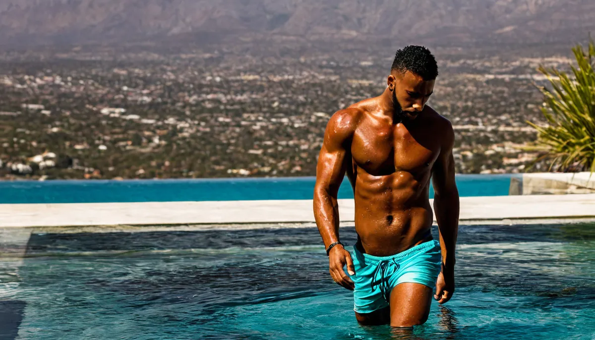 Shirtless man in teal swim shorts wading out of an infinity pool, AI-generated decorative image